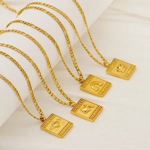 Detail of four gold Figaro chain necklaces with embossed crown and heart wing pendants