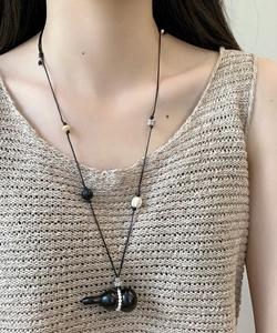 Detail of vintage adjustable wax rope necklace with wooden gourd pendant on a model