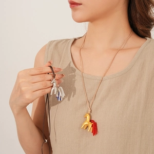 Detail of horse-shaped pendants with colorful glass beads on long wax cord necklaces