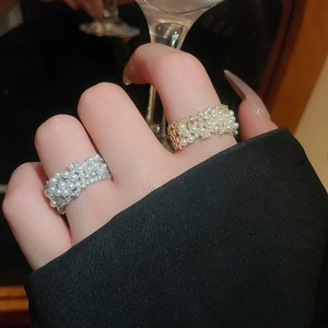Detail of luxury gold and silver plated open rings with pearls and sparkling zircons