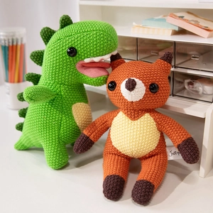 Handmade crochet stuffed animals featuring a green dinosaur and an orange fox for kids
