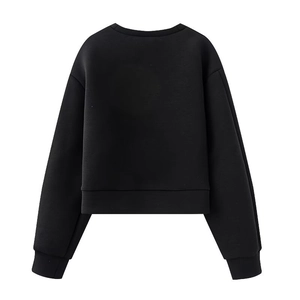 Détail d'un sweat-shirt noir court avec poignets côtelés et un col rond au design minimaliste