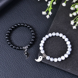 Close-up of Yin Yang couple bracelets with black matte beads and white turquoise stones
