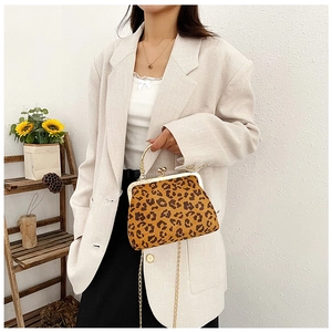 Sac bandoulière chic à motif léopard avec chaîne dorée porté sur un blazer beige
