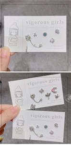 Detail of silver stud earring set with colored zircons and pearls on a display card