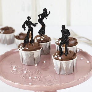 Close-up of black glitter disco dancer cupcake toppers on chocolate desserts