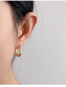 Close-up of minimalist gold S925 sterling silver waterdrop earring on ear model