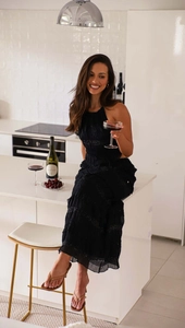 Detail of black tiered chiffon dress featuring subtle pleats and shimmery silk textures