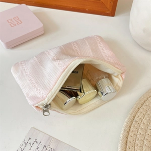 Detailed close-up of pink lace textured makeup bag with premium metal zipper detail