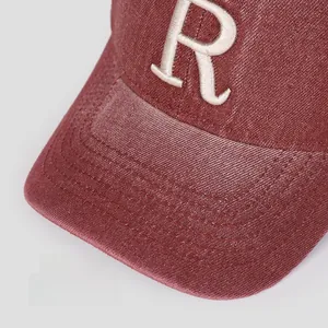 Gros plan sur une casquette bordeaux vintage avec broderie de la lettre R blanche
