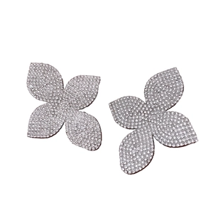 Boucles d'oreilles trèfle à quatre feuilles en argent avec strass pavés sur fond blanc