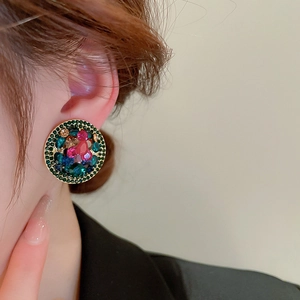 Detailed macro view of vintage round clip-on earring featuring colorful faceted gemstones