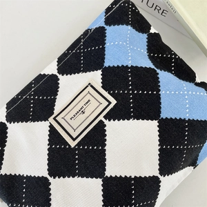 Detailed close-up of checkerboard canvas makeup bag with embroidered brand tag