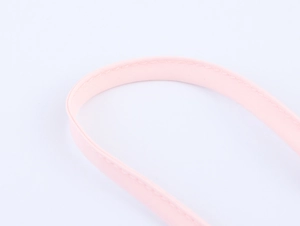 Détail de la bandoulière en tissu rose avec des coutures précises sur une robe d'été