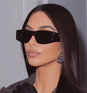 Detail of square oversized black sunglasses with wide temples on a female fashion model