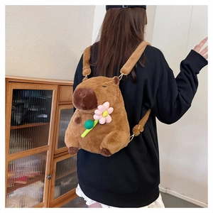 Brown capybara plush backpack with pink flower detail shown on a model's back