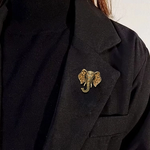 Vintage gold elephant brooch with amber rhinestones on a black suit lapel