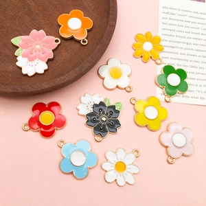 Flat lay of colorful enamel daisy and flower pendants for creative keychain DIY accessory