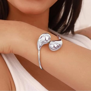 Polished silver teardrop open cuff bracelet shown on model wrist for elegant style