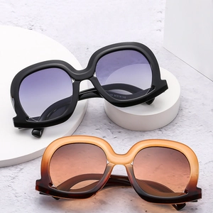 Chic oversized irregular sunglasses with black and gradient amber frames on display