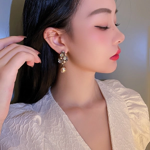 Vintage floral pearl earrings with shimmering crystals on model in a soft close-up view