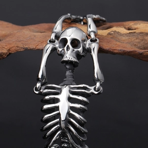 Detailed macro view of Gothic silver skull and rib cage skeleton link bracelet on wood