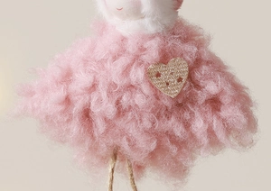 Détail de la poupée ange rose en peluche avec cœur scintillant et jambes en ficelle