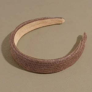 Detail of a brown woven headband with visible braided texture and smooth inner lining
