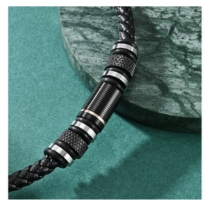 Macro shot of black braided leather bracelet with rose gold and knurled metal beads