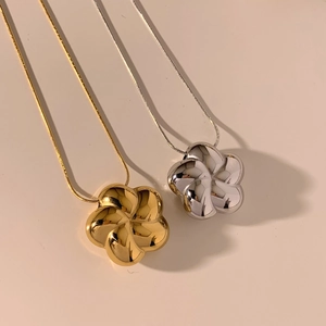 Close-up of 3D hollow flower pendants in gold and silver finish with fine chains