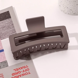 Macro shot of matte coffee brown hair claw clip on magazine with soft natural lighting