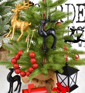 Close-up of golden reindeer ornaments and red mailboxes hanging on a Christmas tree