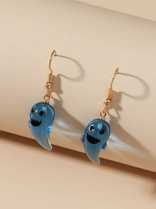 Close-up of translucent blue resin ghost earrings with gold hooks on a cream background