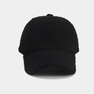 Close-up of black fuzzy sherpa fleece texture on a warm winter baseball cap