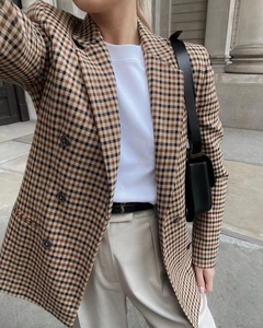 Detail eines klassischen zweireihigen Plaid-Blazers mit kariertem Stoff und Knöpfen