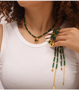 Gros plan détaillé d'un collier en perles vertes avec pendentif cœur doré et zircon
