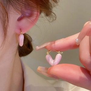 Dettaglio degli orecchini a cuore rosa opale con chiusure in metallo dorato