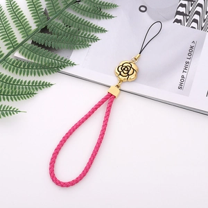 Detailed shot of pink woven phone lanyard with golden rose charm and metallic accents