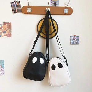 Detail of cute ghost-shaped PU crossbody bags in black and white with woven straps