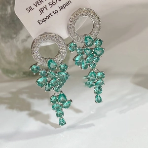 Vue macro de boucles d'oreilles en argent avec pierres vert menthe et zircon