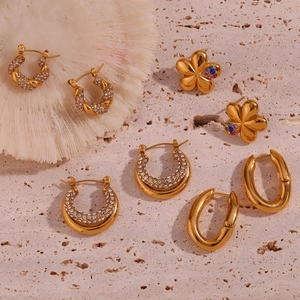 Detail of four pairs of 18K gold plated titanium earrings with rhinestones and flowers