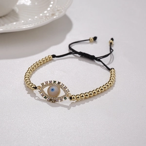 Detailed close-up of golden evil eye bracelet with colorful zircons and adjustable black cord
