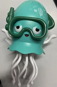 Close-up of mint green jellyfish diver toy with translucent tentacles and marine patterns