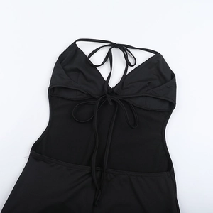 Detail of black halter neck jumpsuit with open back tie-up design and knit texture