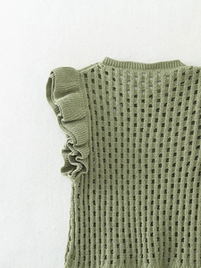 Détail du haut en tricot vert haricot avec manches volantées et texture ajourée élégante