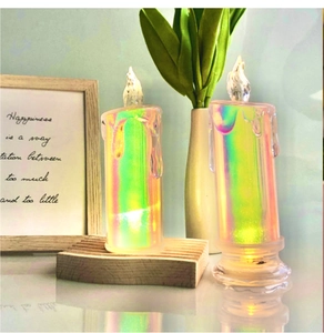 Detailed view of two iridescent LED candles with warm flame effect in a cozy home setting