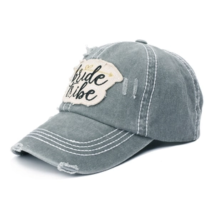 Close-up of distressed bride tribe embroidery patch on washed grey cotton baseball cap