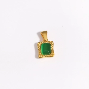 Macro shot of gold square pendant featuring an emerald-green zircon with hammered edges