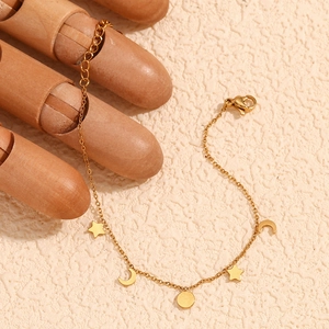 Detail of 18K gold plated stainless steel chain with star, moon and disc charms