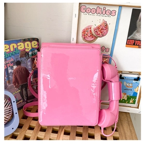 Macro shot of bright pink vintage telephone bag with high-gloss finish and handset detail